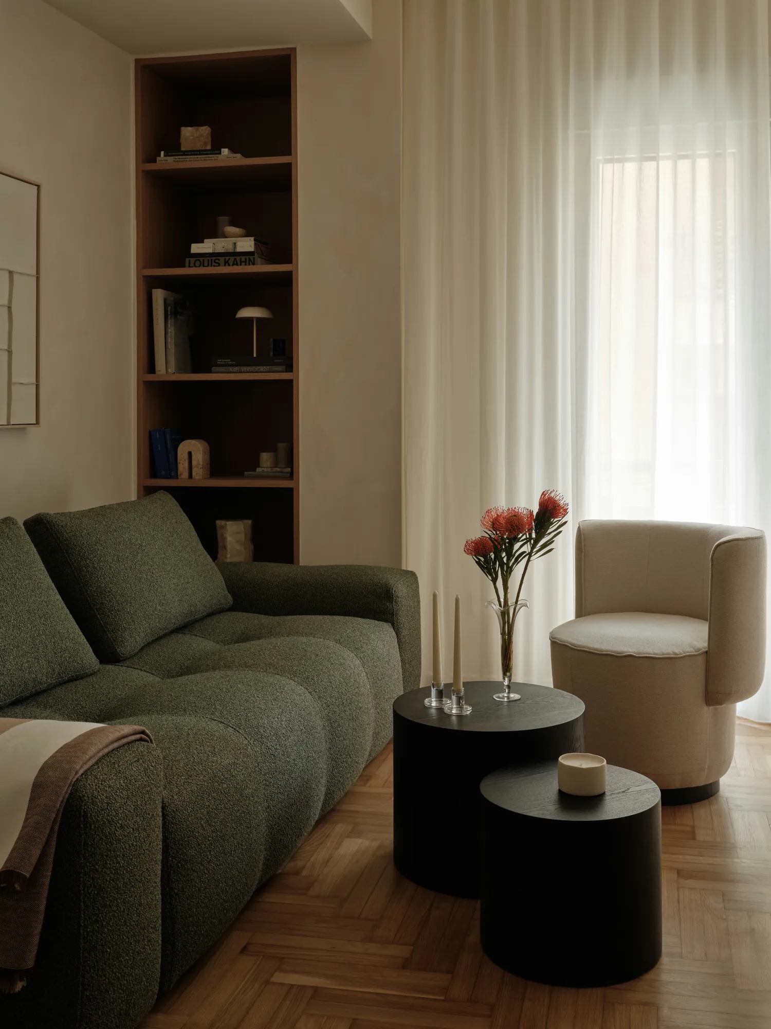 Curved sofa and shelving beside a softly lit window