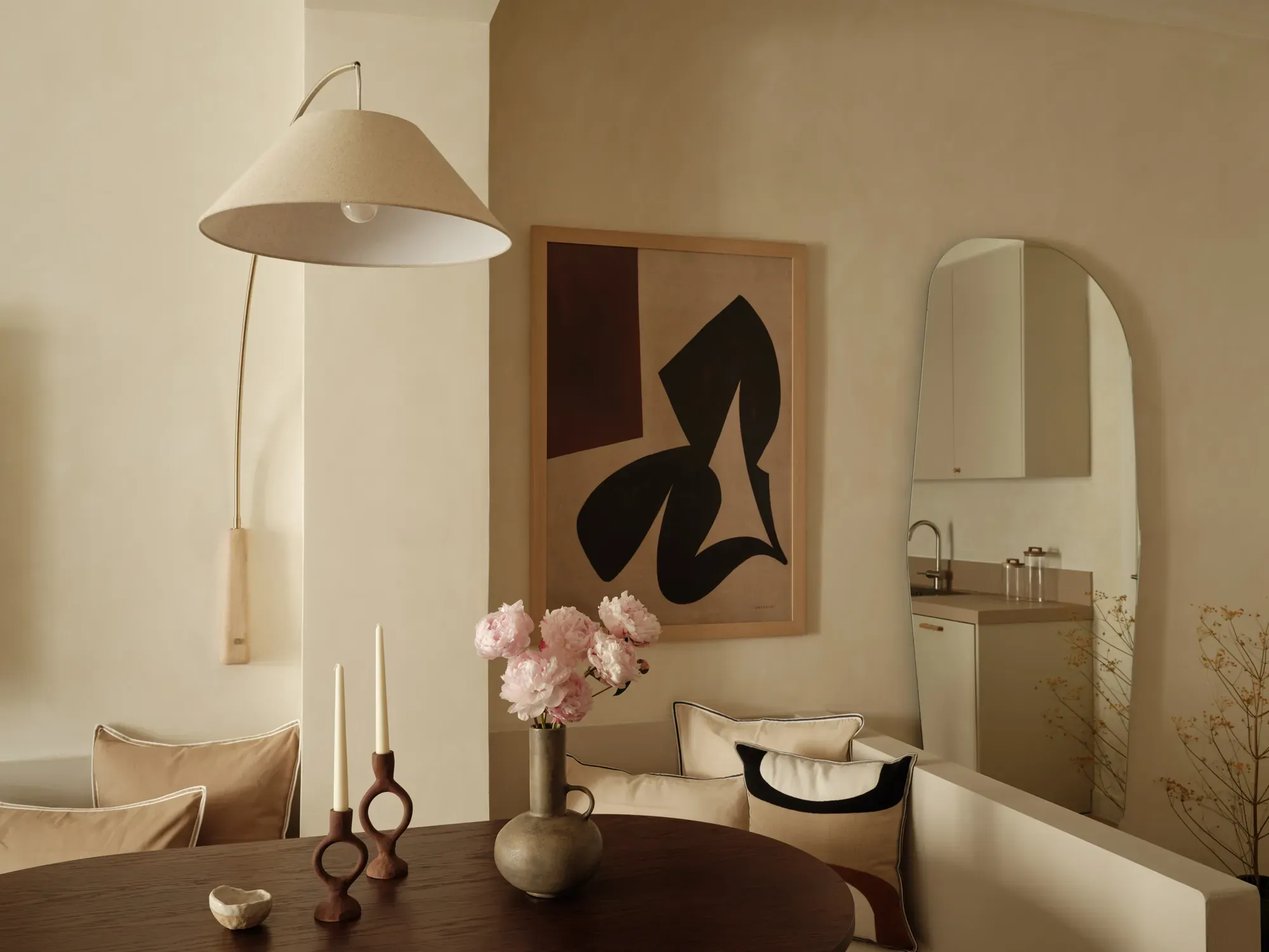 Dining area with a curved banquette and arched wall mirror