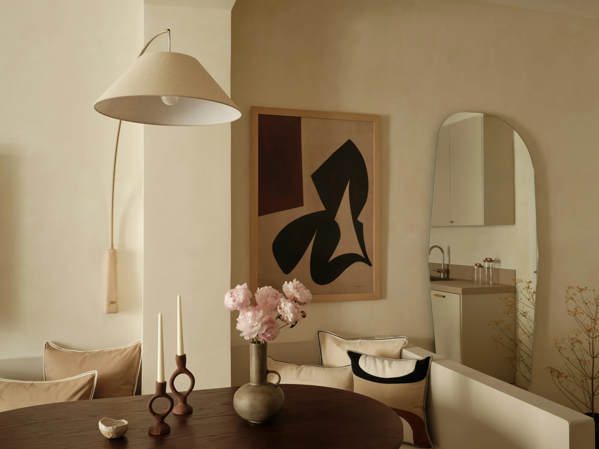 Dining area with curved banquette and arched wall mirror