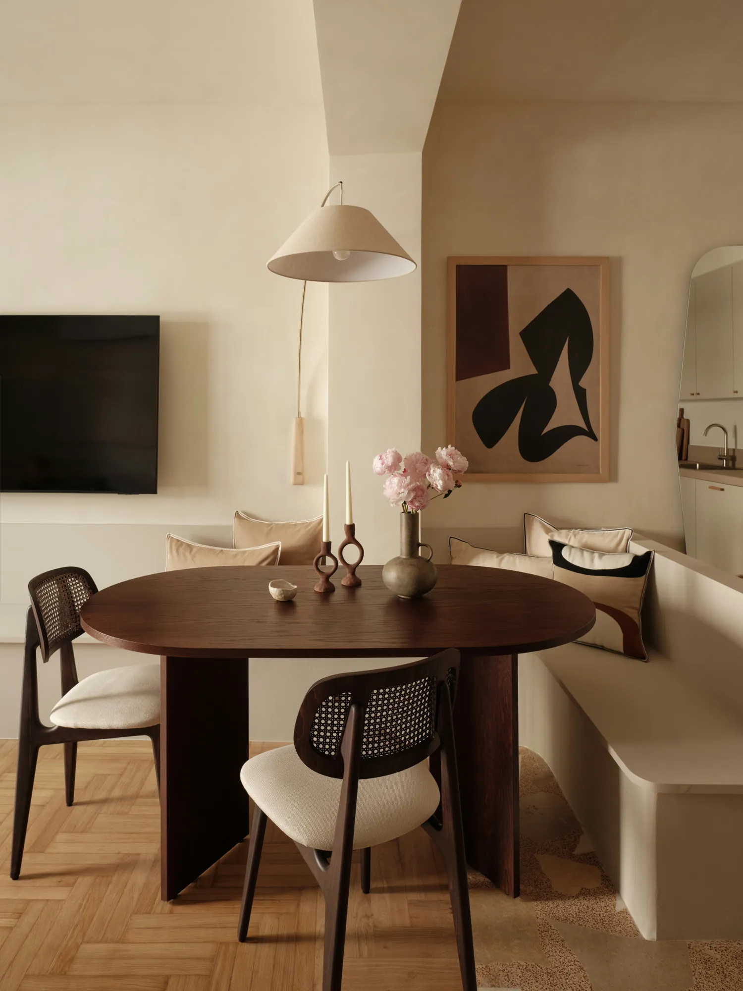 Timber dining table and built-in seating beneath a pendant light