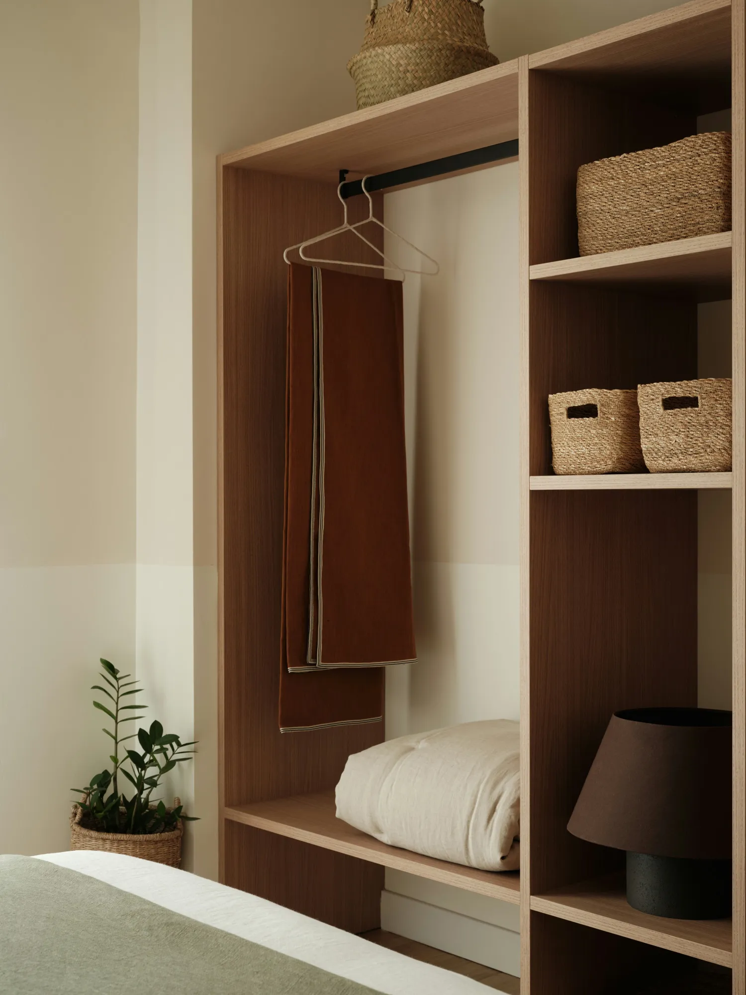 Open timber wardrobe with hanging rail and woven storage baskets