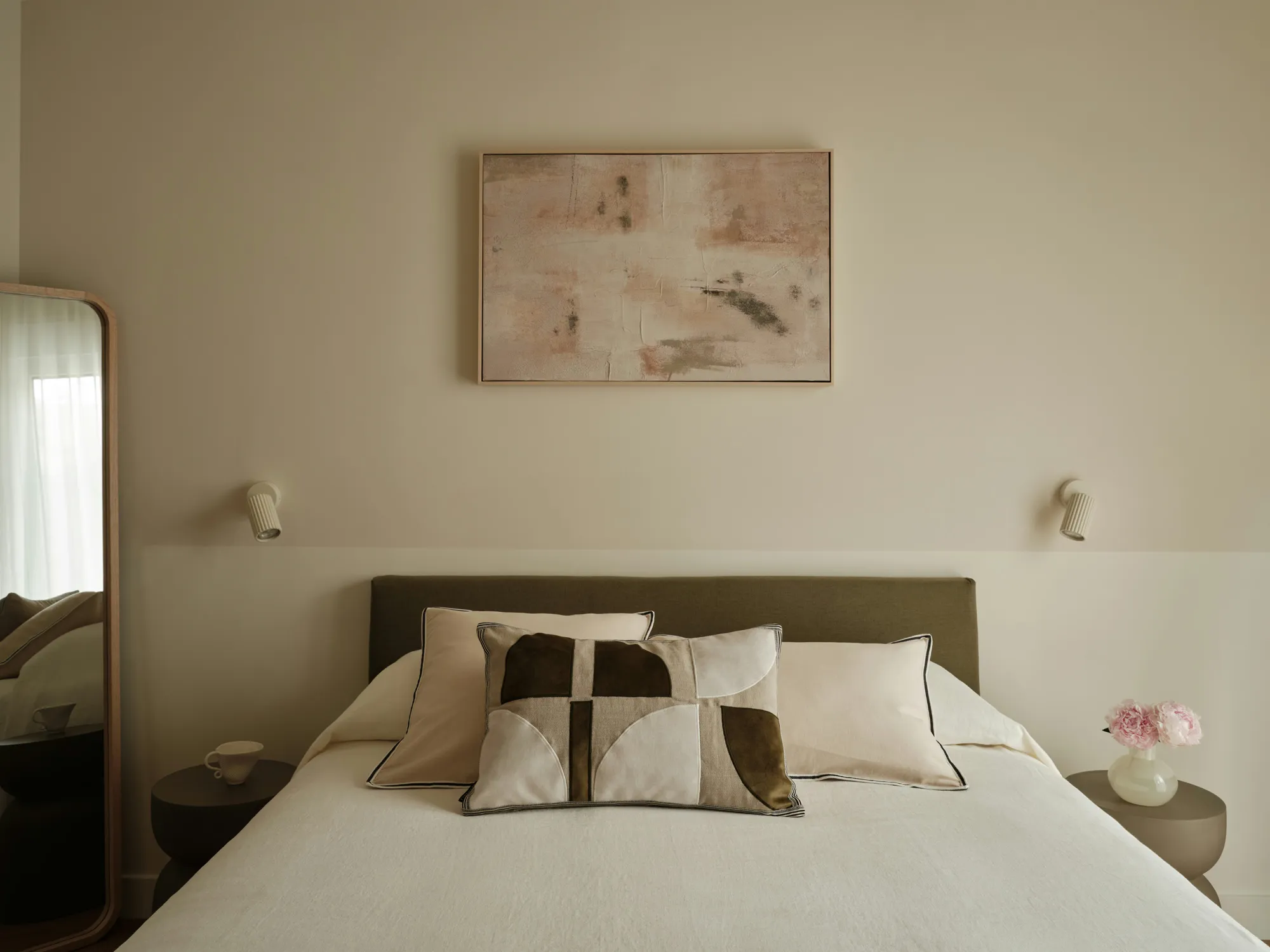 Principal bedroom with upholstered bed and wall-mounted lights