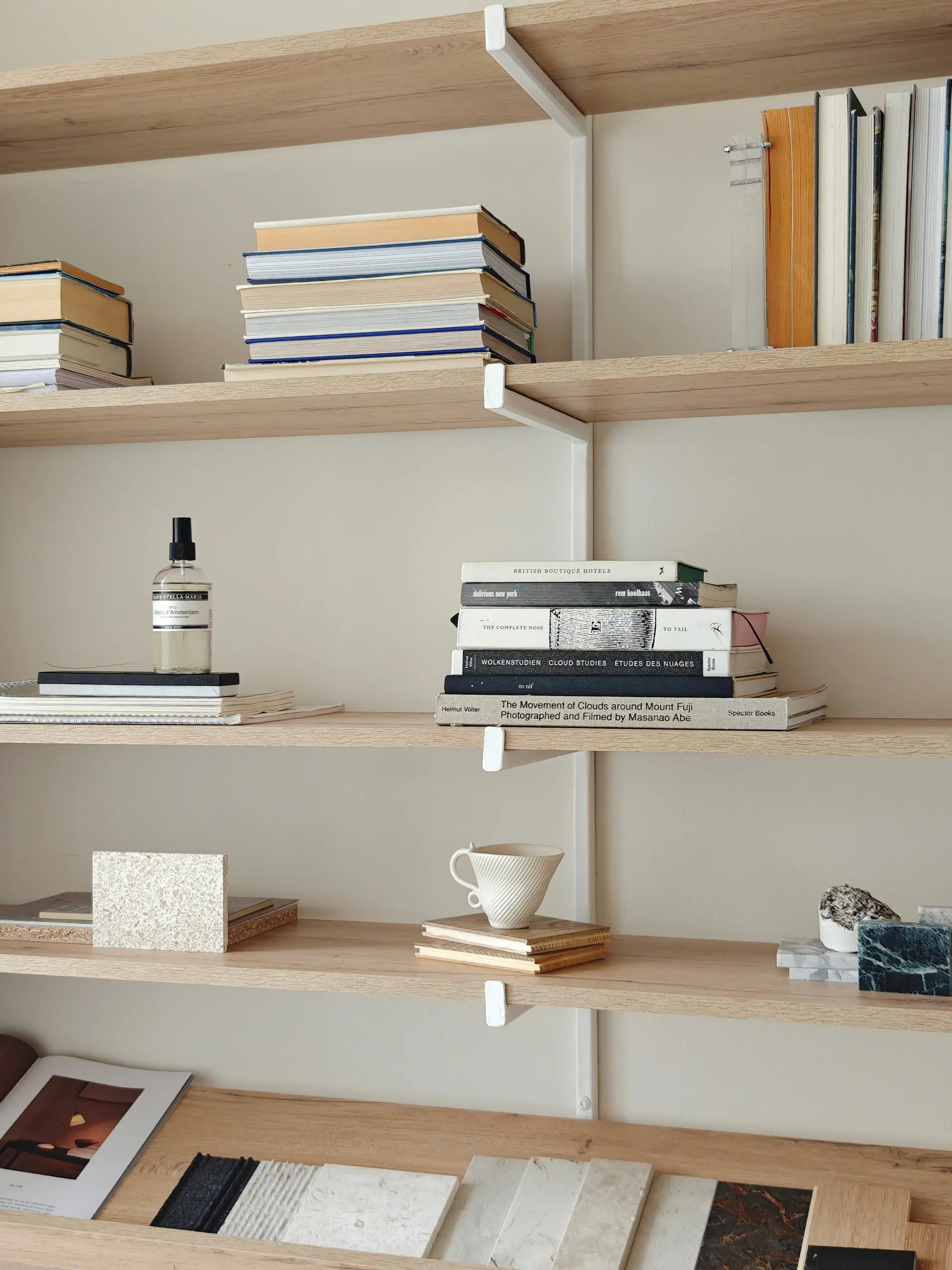 Books, material samples and objects arranged on the studio’s timber shelving