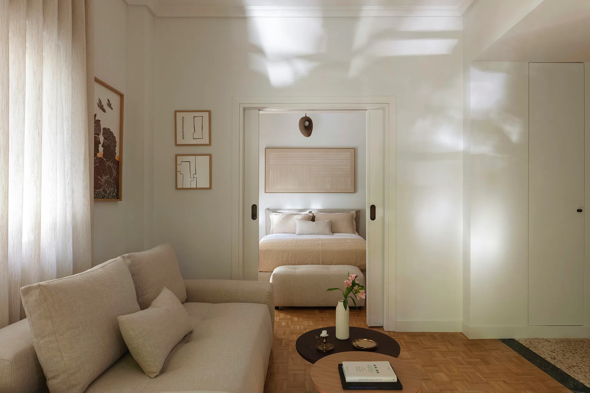 Sunlit living room opening through sliding doors to the bedroom in the Kolonaki Residence