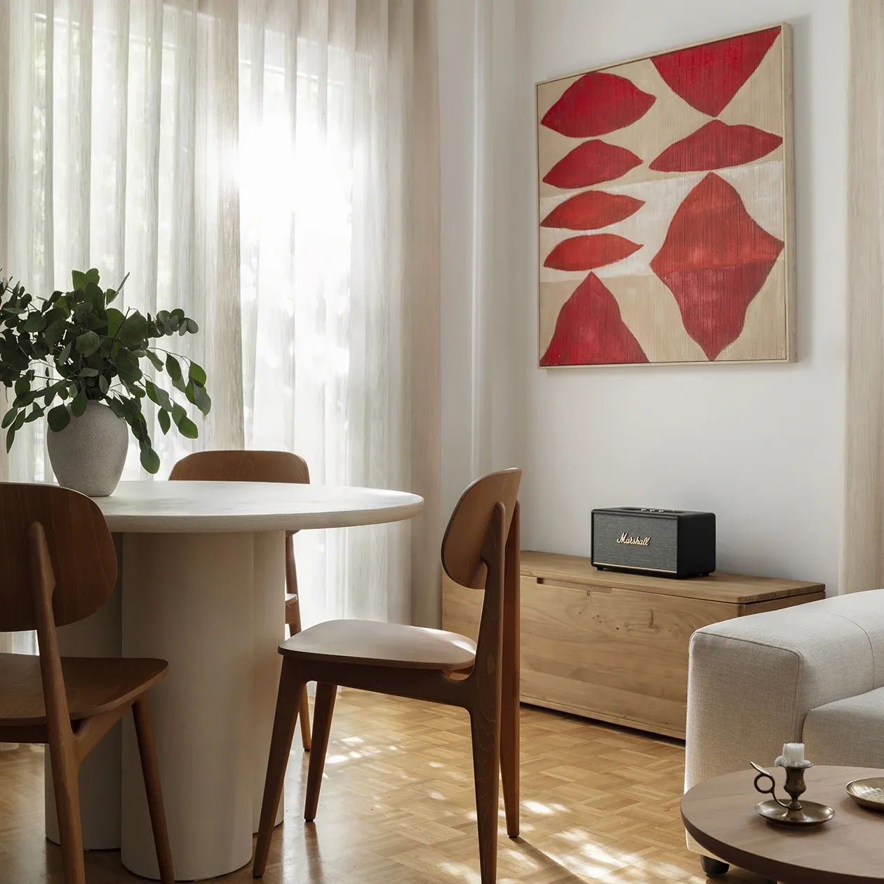 Sunlit dining area with timber chairs and red artwork in the Kolonaki Residence