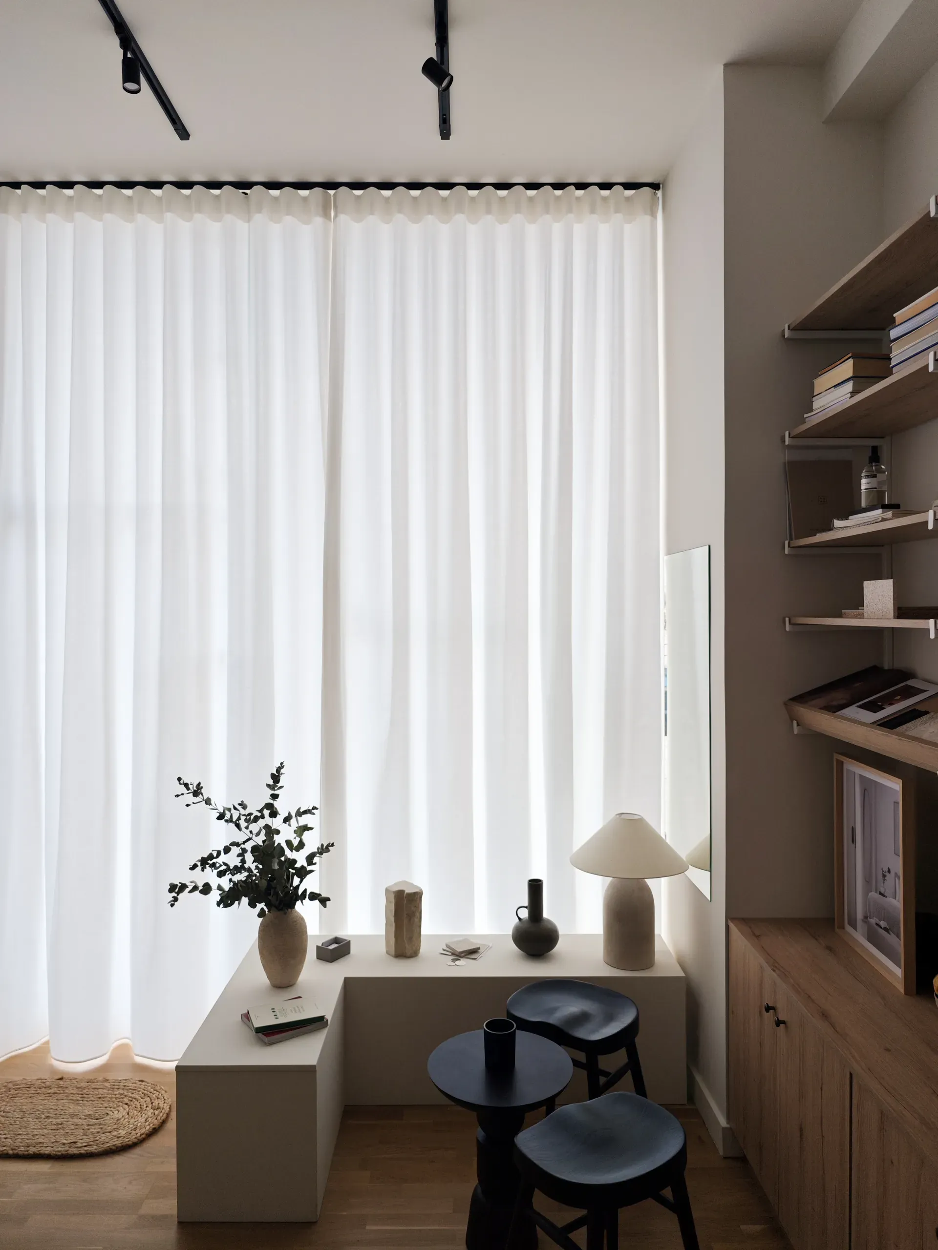 Compact meeting area beside the softly curtained shopfront