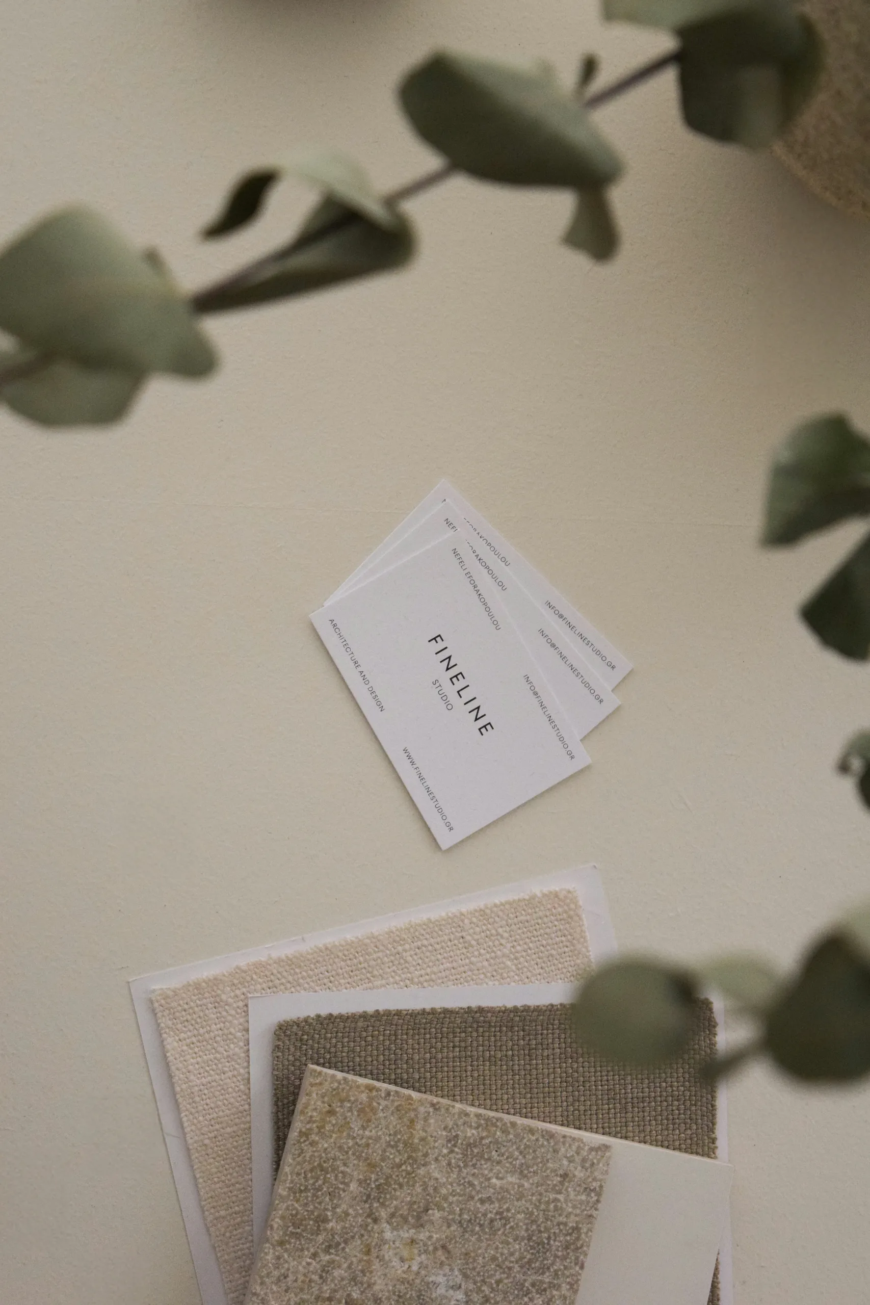 Fineline Studio cards with fabric and stone samples on a worktable
