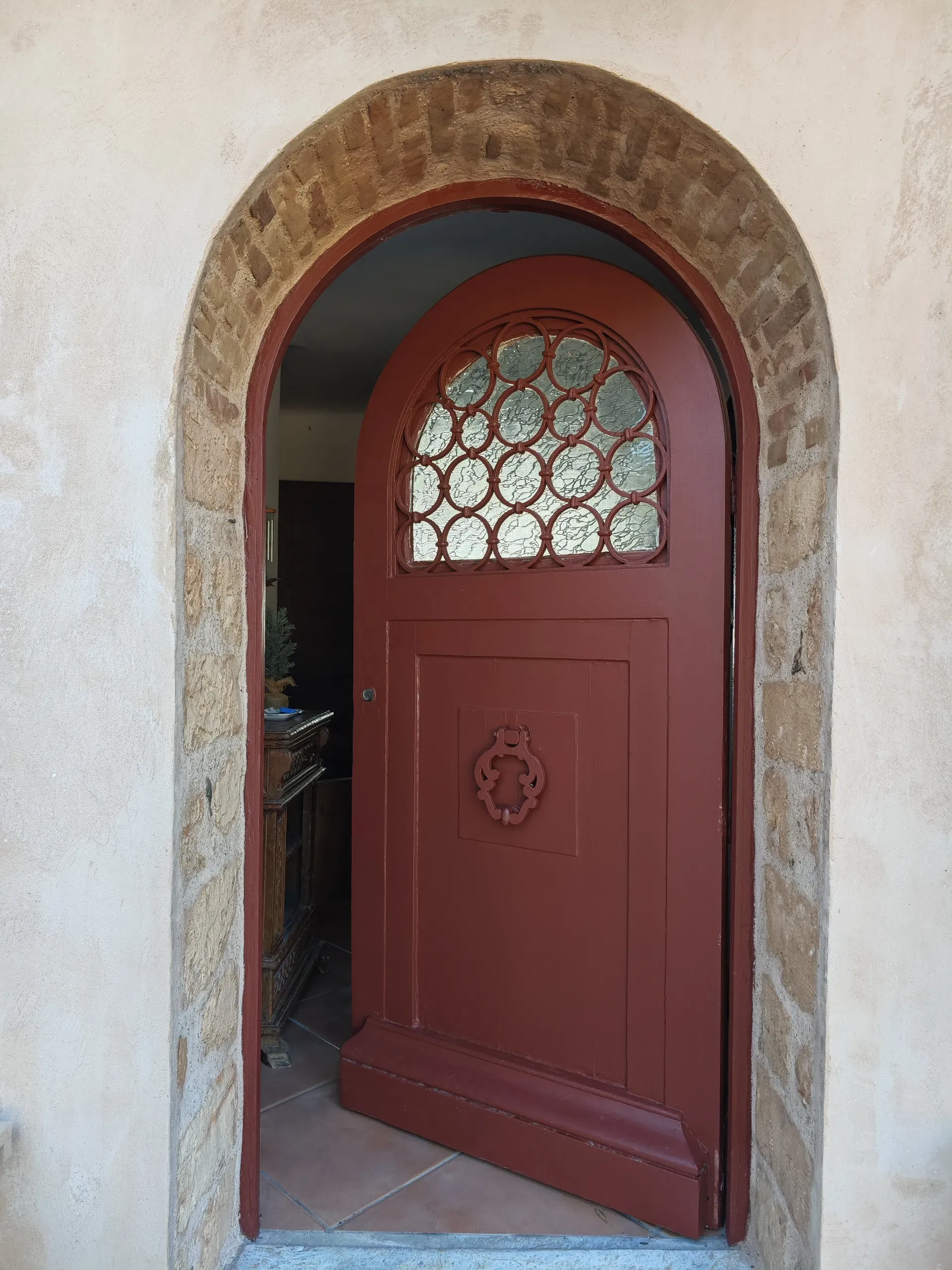 Original red arched entrance door with patterned glazing