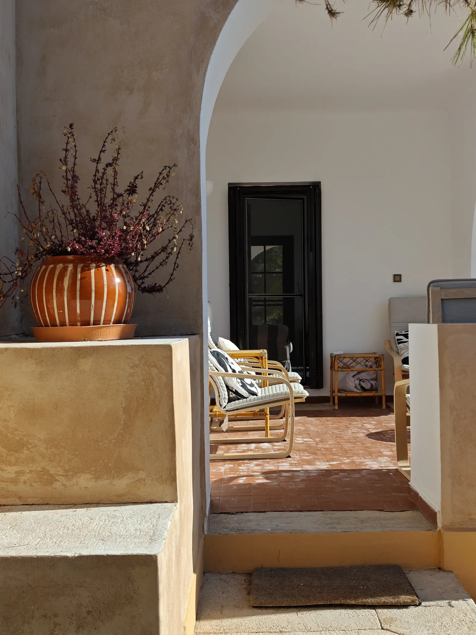Existing terrace seating framed by rendered arches and a ceramic planter