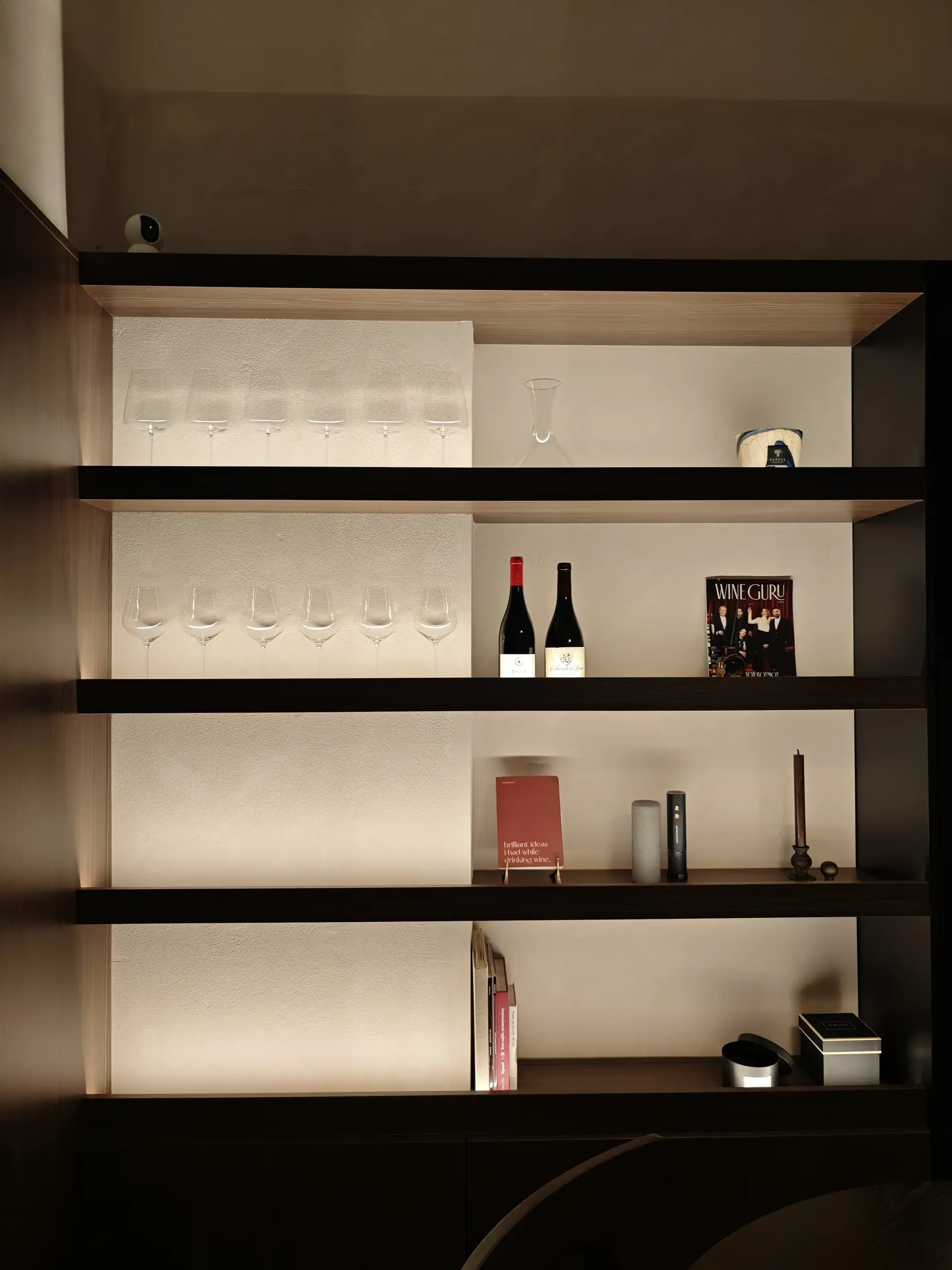 Full-height open shelving with integrated lighting for glasses, books and wine